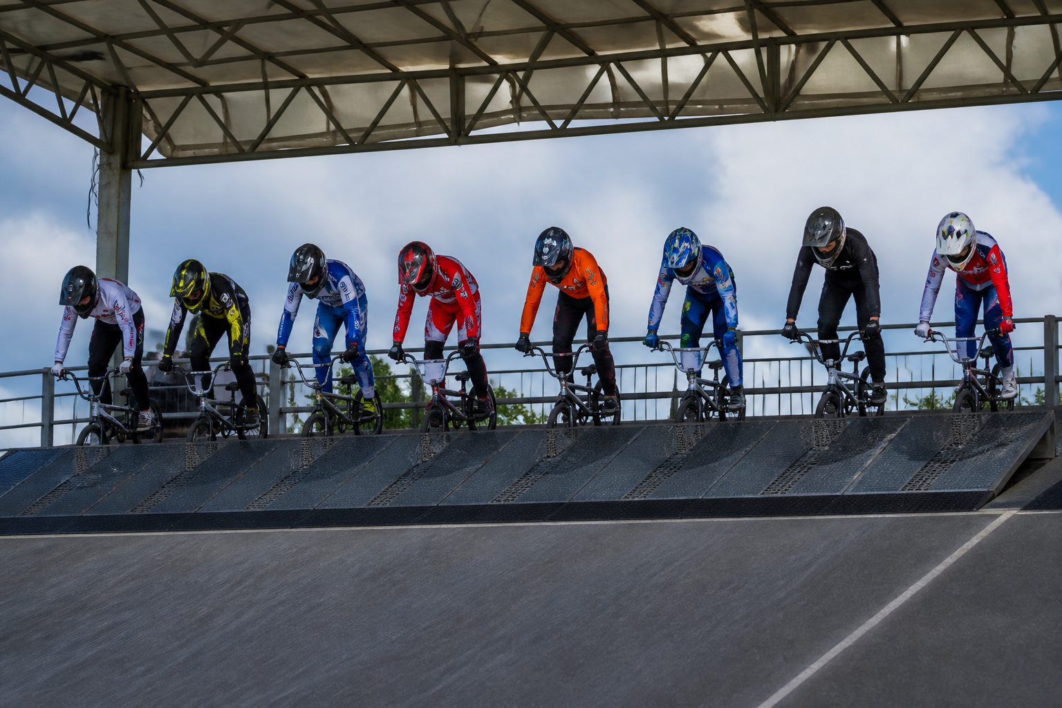 huit pilotes bmx race en position de départ sur la rampe de lancement