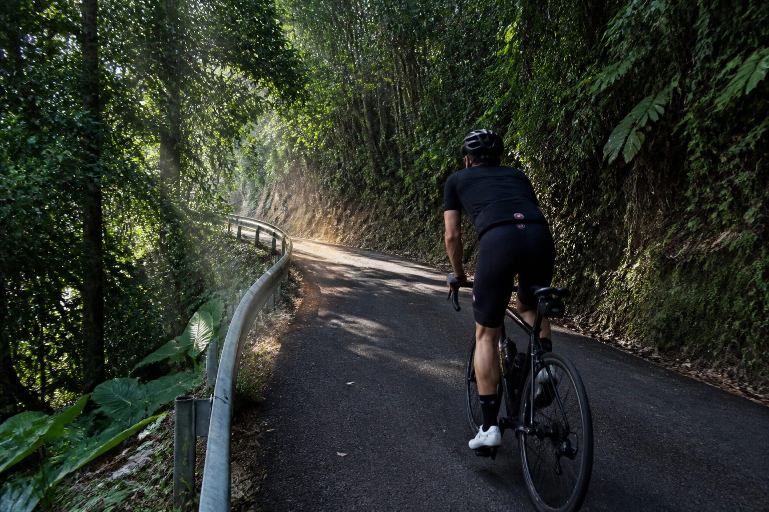Cycliste en montée sur la route de Bouillante — côte sous-le-vent à vélo Basse-Terre
