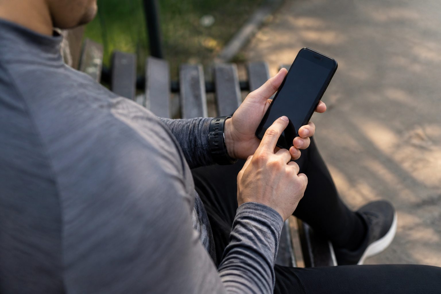 Coureur qui crée son compte Strava gratuit sur smartphone dans un parc urbain
